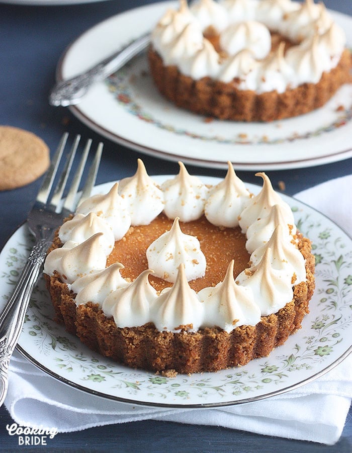 a sweet potato tart and metal forkon a green and white floral plate with a second tart in the background