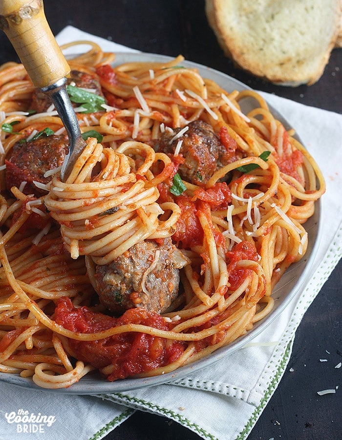 forkful of pasta and a meatball on the end of a fork