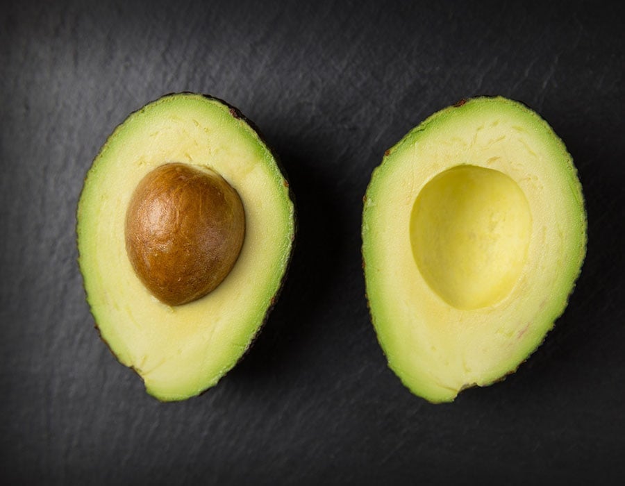 sliced avocado lying face up on a black background