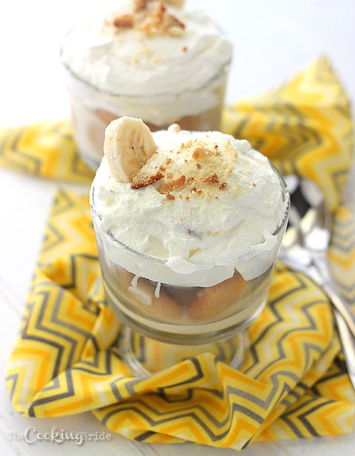 trifle bowl of banana pudding topped with whipped cream and crushed vanilla wafers