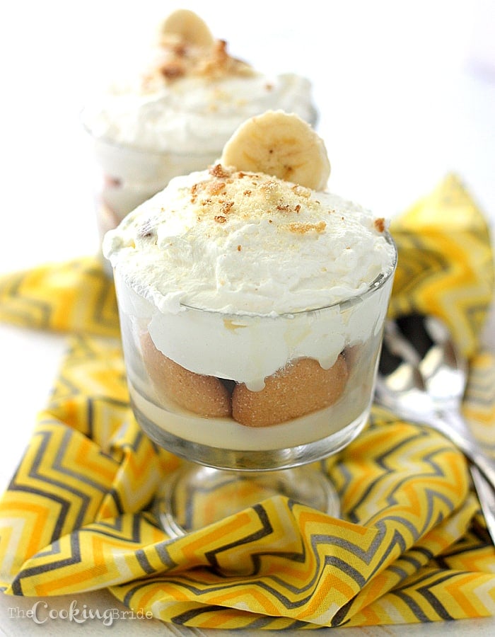 trifle bowl of banana pudding topped with whipped cream and crushed vanilla wafers