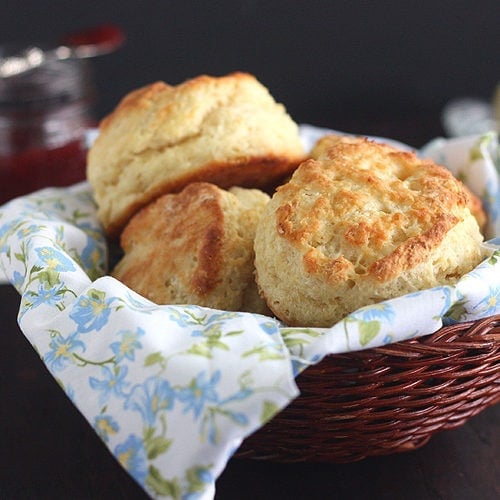 buttermilk biscuits in a basket lined with a floral napkin
