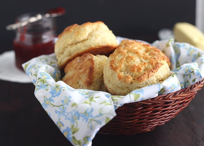 buttermilk biscuits in a basket lined with a floral napkin