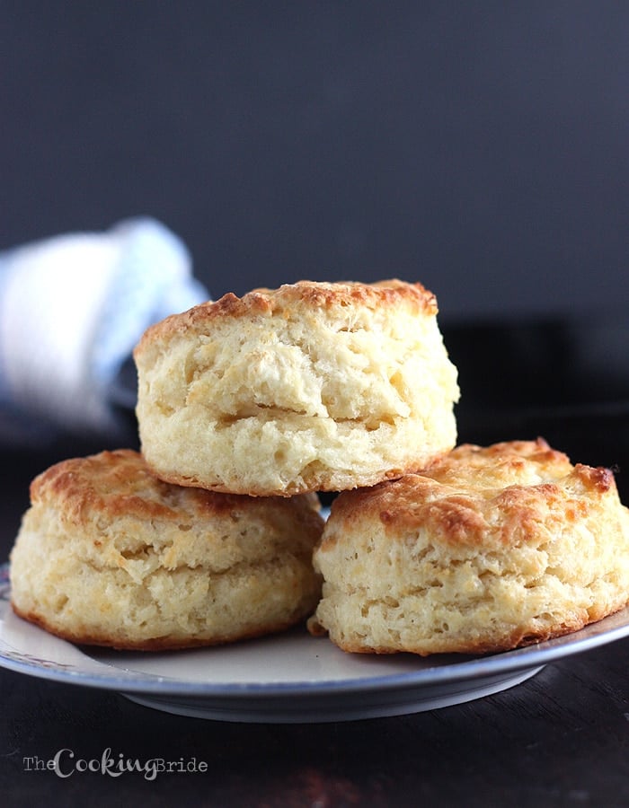 three buttermilk biscuits stacked on a plate