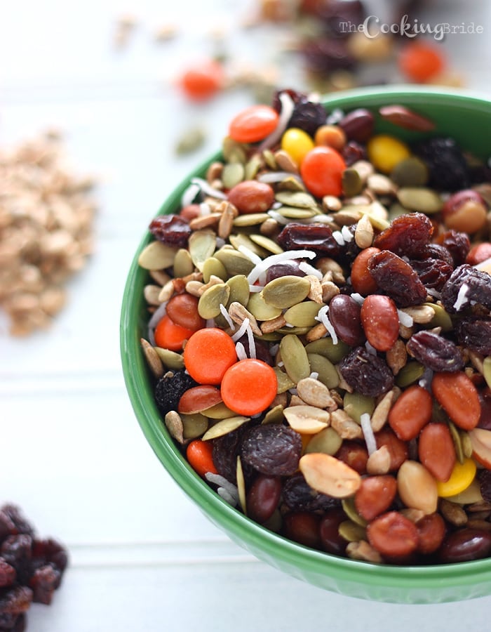 trail mix in a green bowl on a white background