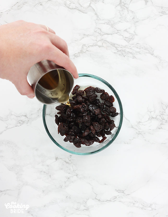 pouring bourbon over raisins to rehydrate them