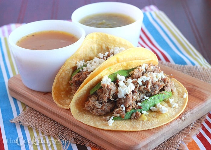 Pork shoulder is braised in onion and spices, then shredded and served on a corn tortilla with sliced avocado and queso fresco for a delicious pulled pork carnitas recipe.