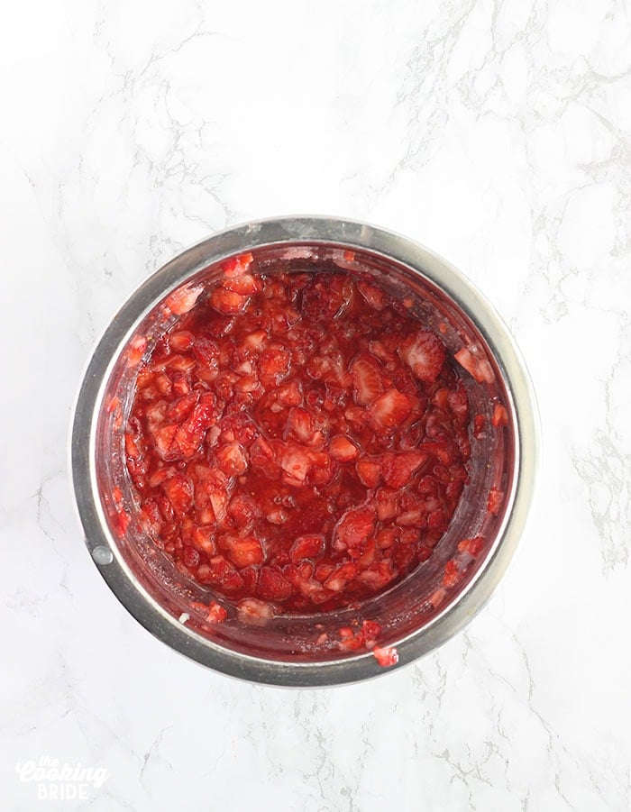 metal bowl of diced strawberries soaking in lemon juice and sugar