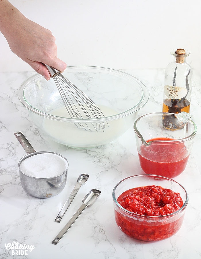 mixing the sugar into the heavy cream with other ingredients nearby to be mixed in