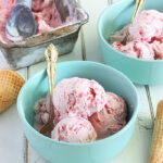 strawberry ice cream in light blue bowls on a white background