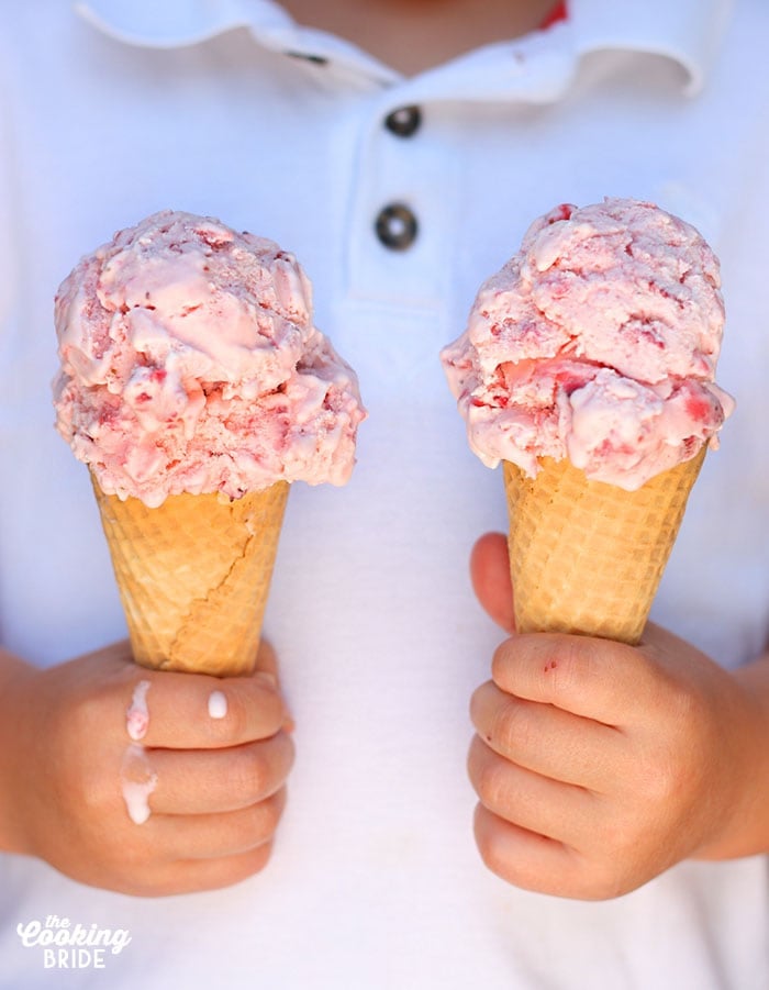 child holding an ice cream cone in each hand