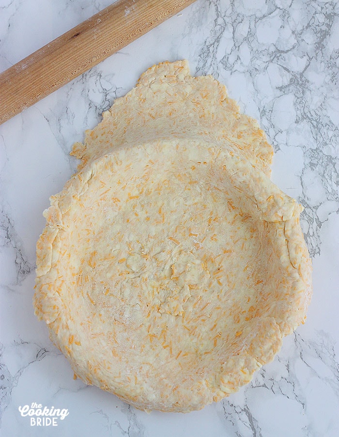 cheddar cheese pie crust rolled out into a pie plate