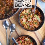 Two individual bowls of baked beans garnished with chopped bacon and sliced green onions.