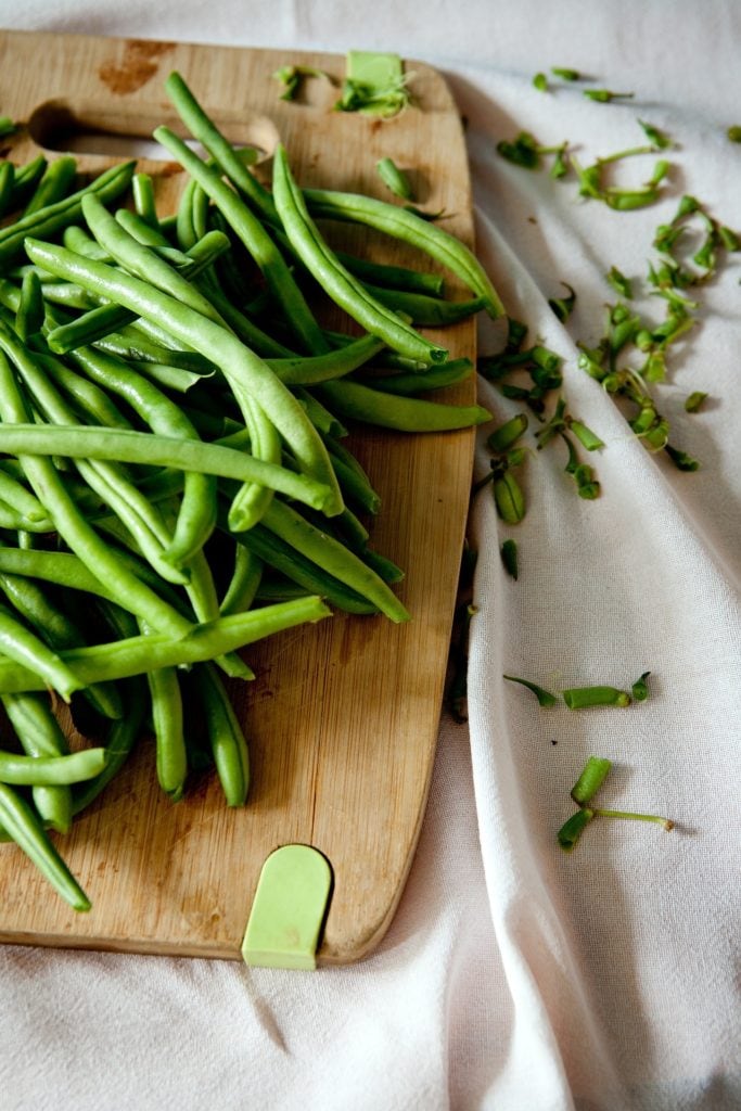 fresh green beans on a cutting board