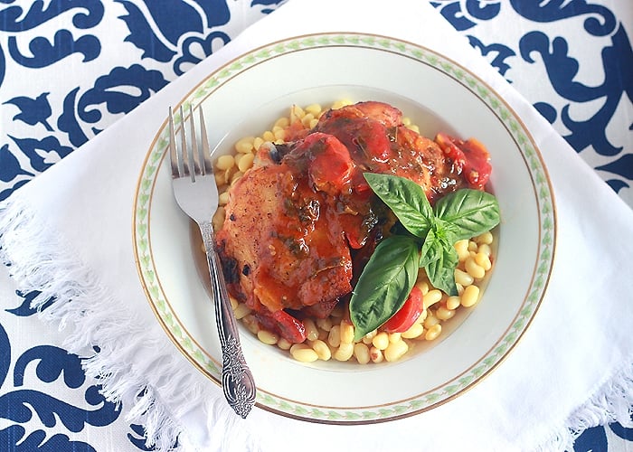 Healthy chicken thighs recipe is roasted in the oven with aromatic garlic and fennel then covered in a rich tomato herb sauce.