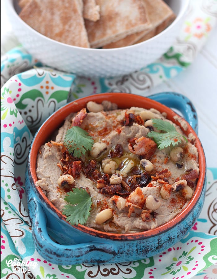 black eyed pea hummus in a blue dish topped with whole peas and parsley