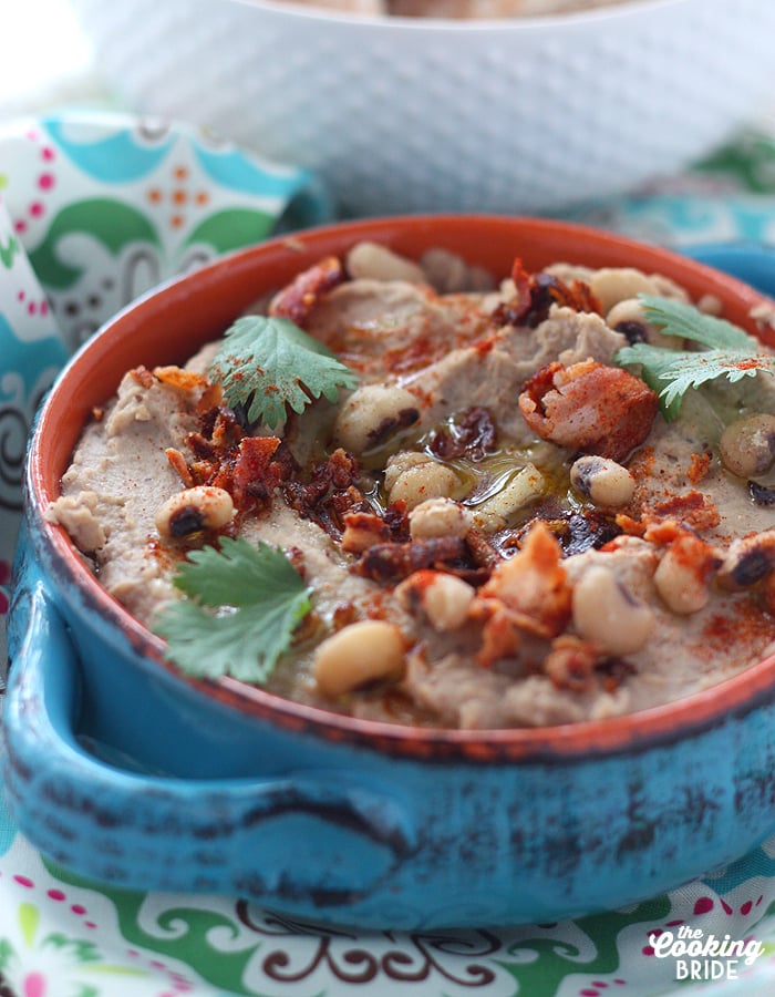 black eyed pea hummus in a blue dish topped with whole peas and parsley