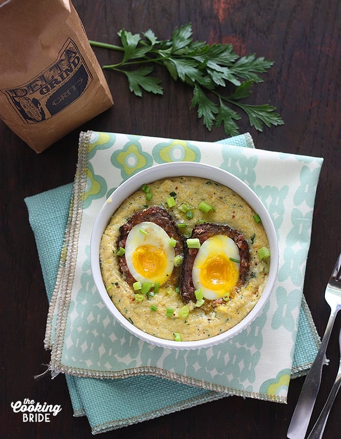 overhead shot of Scotch eggs in a bowl of corn grits on a blue napkin