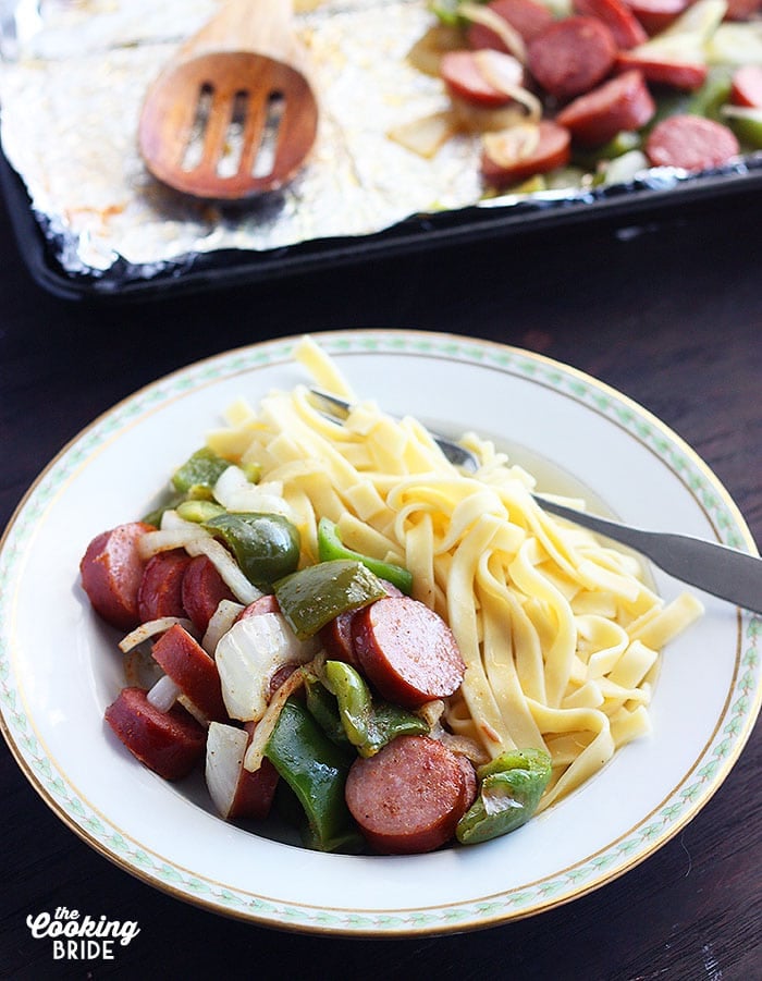 sausage and veggies served in a white bowl with egg noodles