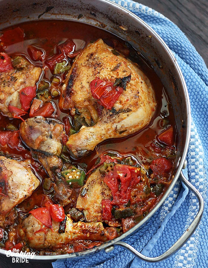 roasted chicken thighs in a skillet with okra and tomatoes