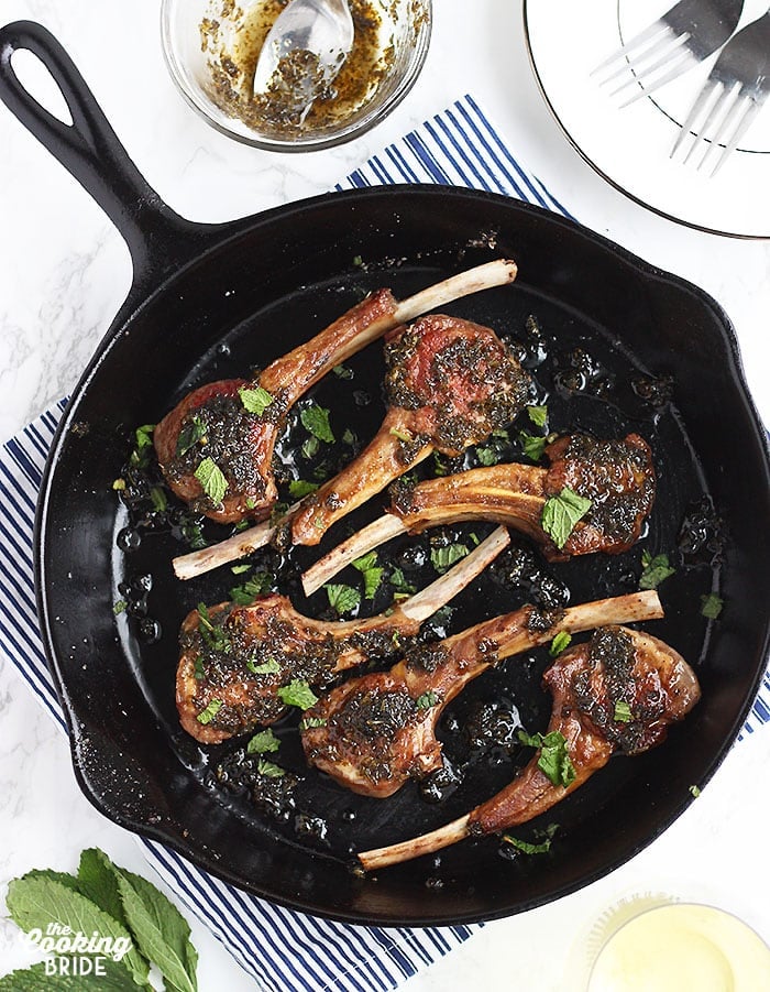 overhead shot of six lamb chops in a cast iron skillet