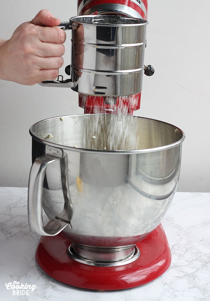 sifting powdered sugar into a mixing bowl