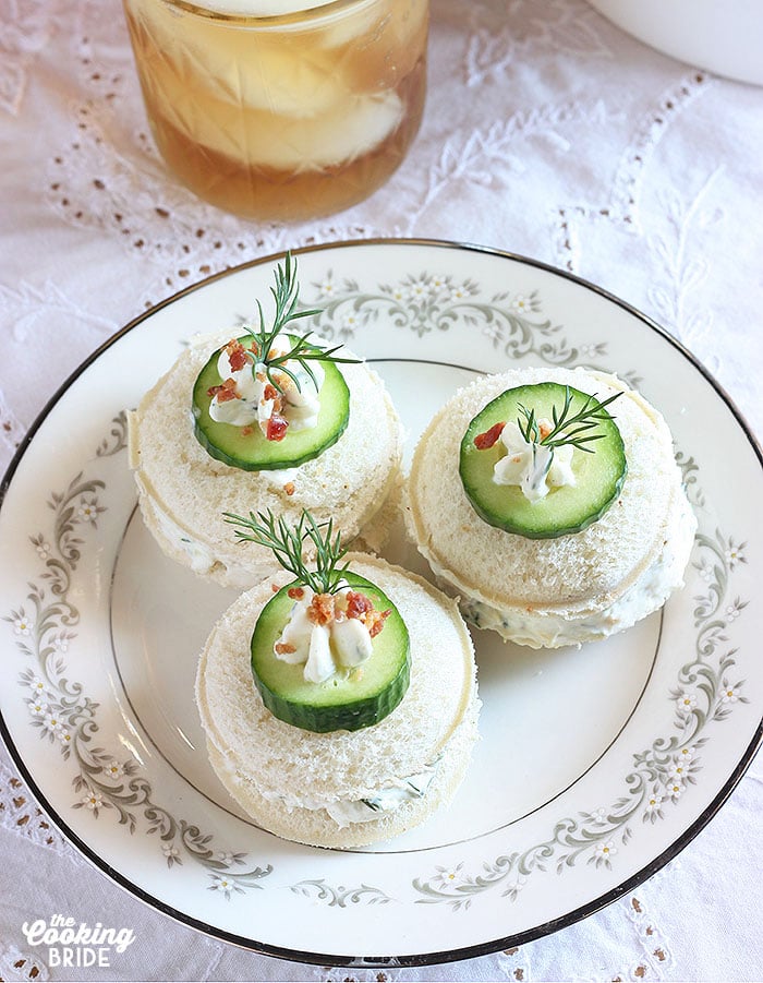 Three cucumber tea sandwiches on a white floral plate