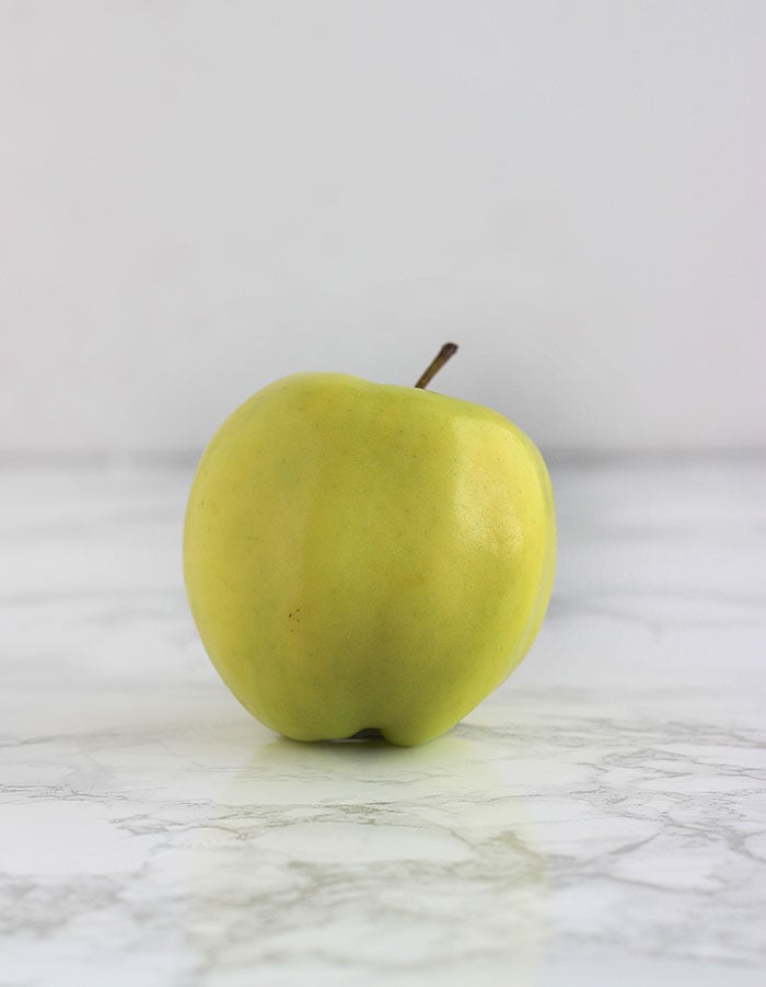 yellow golden delicious apple on a white background