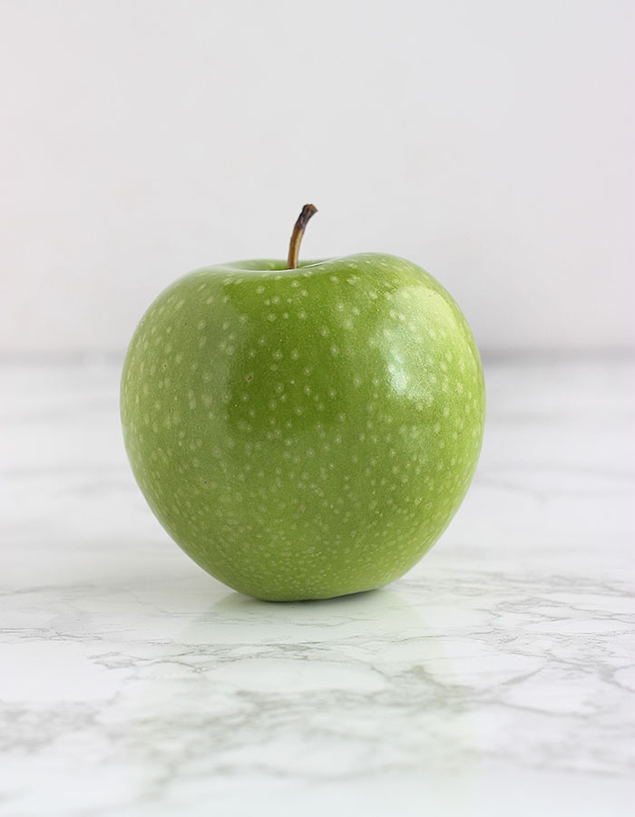 green Granny Smith apple on a white background