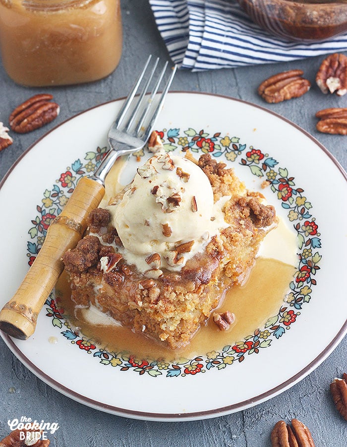 slice of pumpkin crunch cake topped with ice cream on a white place