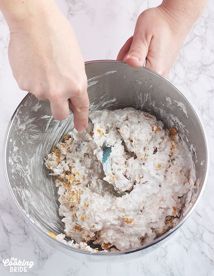 stirring the crushed cornflakes into the whipped egg whites