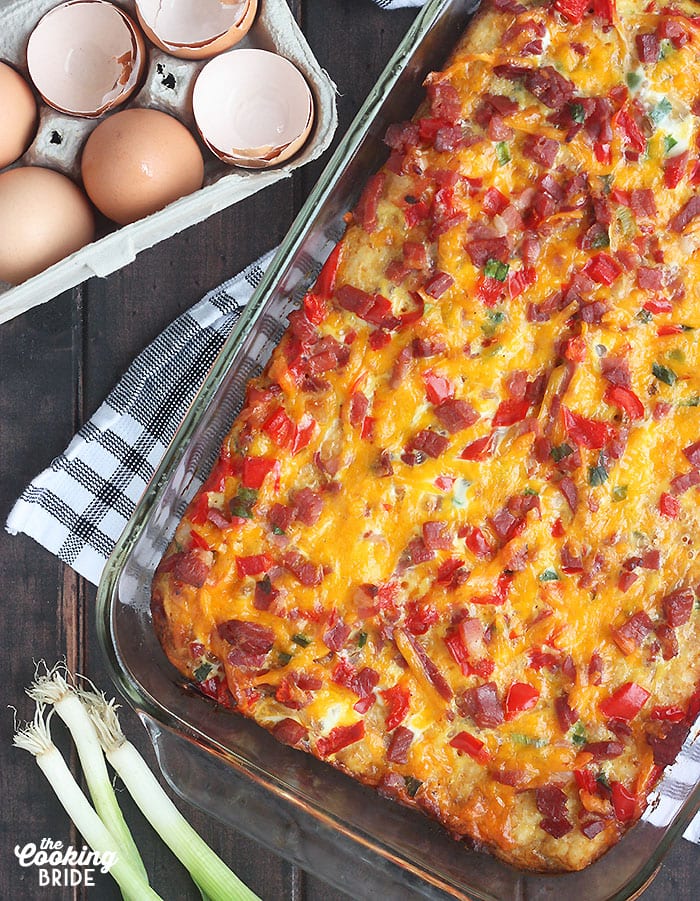 baked ham and cheese breakfast casserole surrounded by eggs and green onions