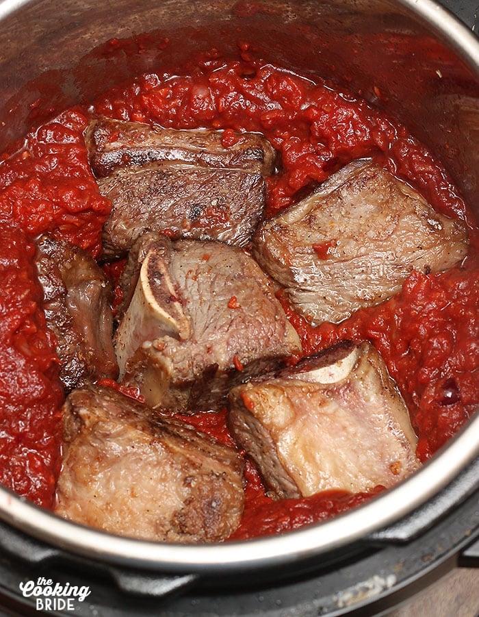 Nestling the browned shortribs in the tomato sauce and vegetables