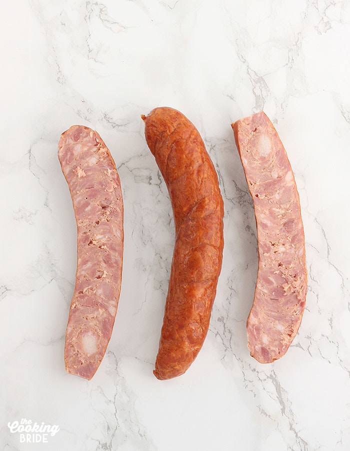 sliced andouille sausage on a white marble background