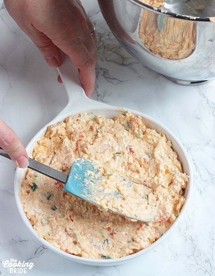 spreading the unbaked crawfish dip into a baking dish