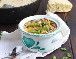 poblano chicken chowder in a green and white bowl garnished with green onions