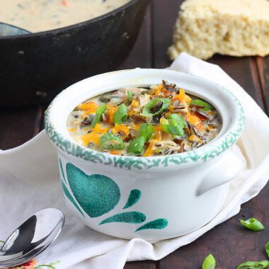poblano chicken chowder in a green and white bowl garnished with green onions
