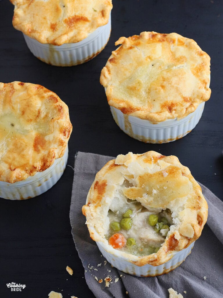 a mini chicken pot pie with a spoonful removed to show the filling