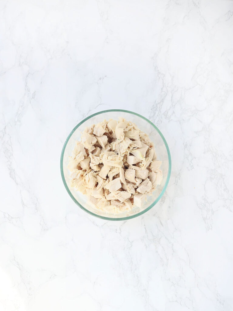 cooked and diced chicken breasts in a glass bowl