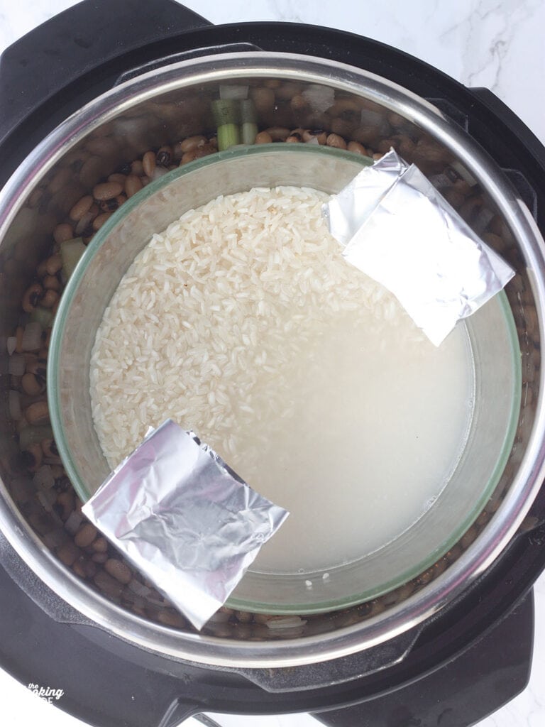 Overhead shot of a bowl of rice on a trivet in an Instant Pot with a foil sling folded over the sides.