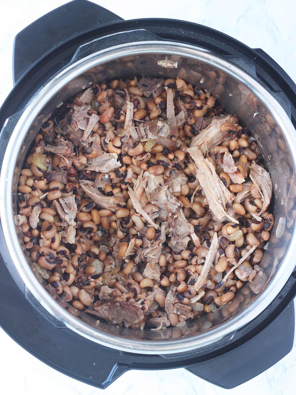 Overhead shot of cooked black-eyed peas with shredded pork in an Instant Pot