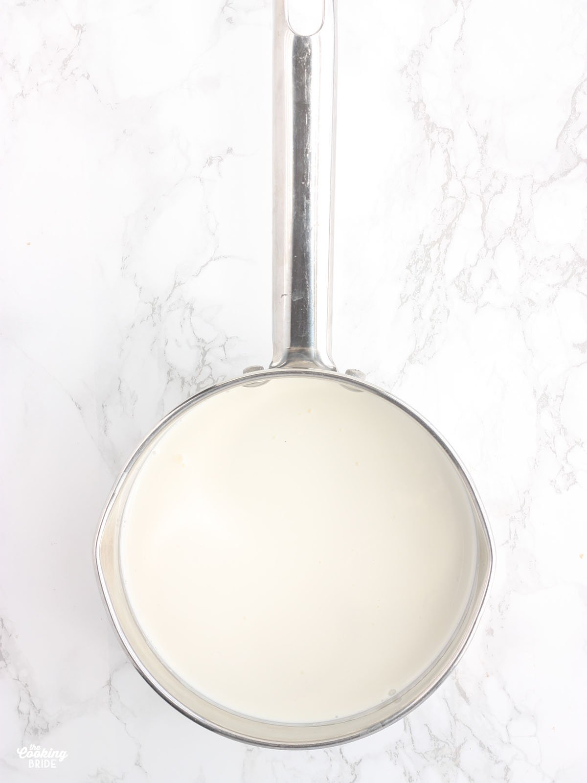 milk and heavy cream warming in a steel saucepan