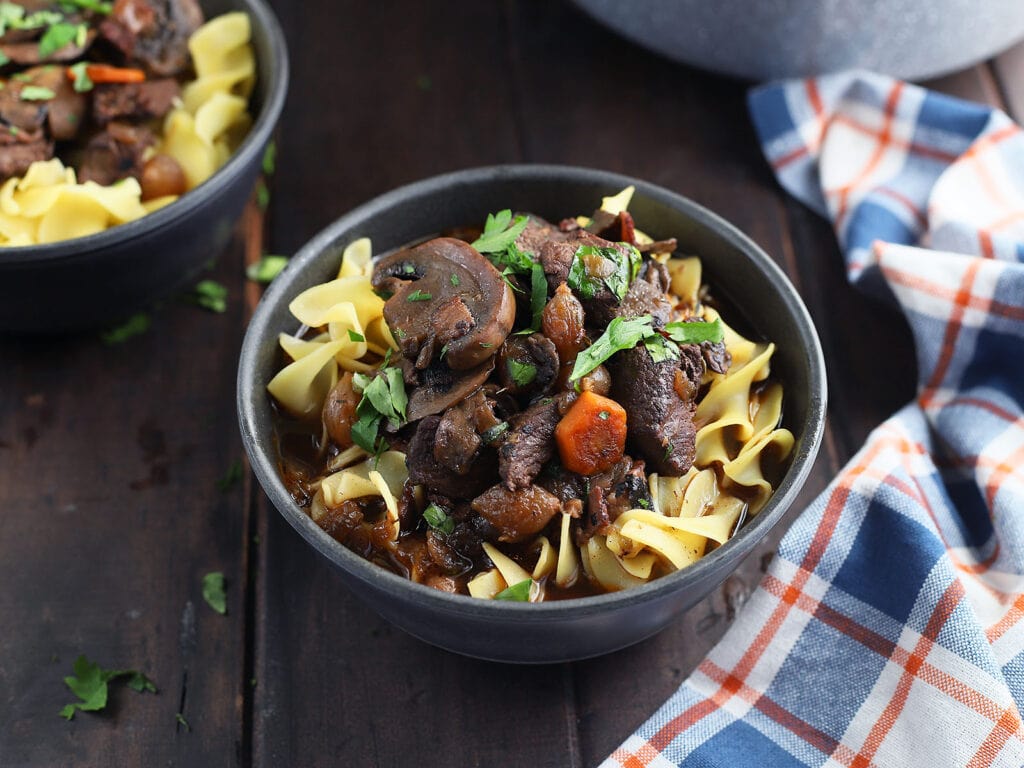 Venison bourguignon over egg noodles garnished with chopped parsley