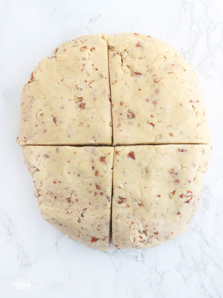 butter pecan cookie dough formed into a disc and cut into four equal parts