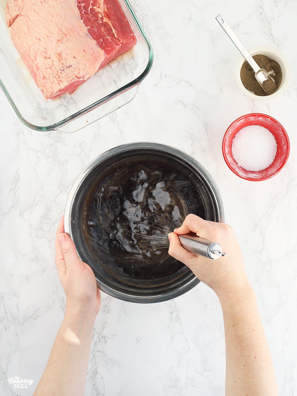 hands whisking together the coca-cola marinade