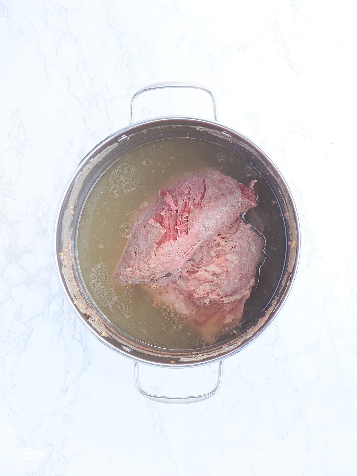 boiled corned beef brisket in a stainless steel stockpot