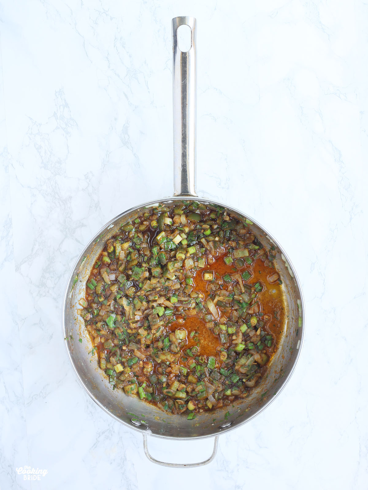 sauteed vegetables, herbs and spices in a stainless steel saucepan