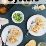 two gray plates with oysters on toast sprinkled with Parmesan cheese, sliced green onions, glasses of white wine, a hand spooning an oyster onto a piece of bread