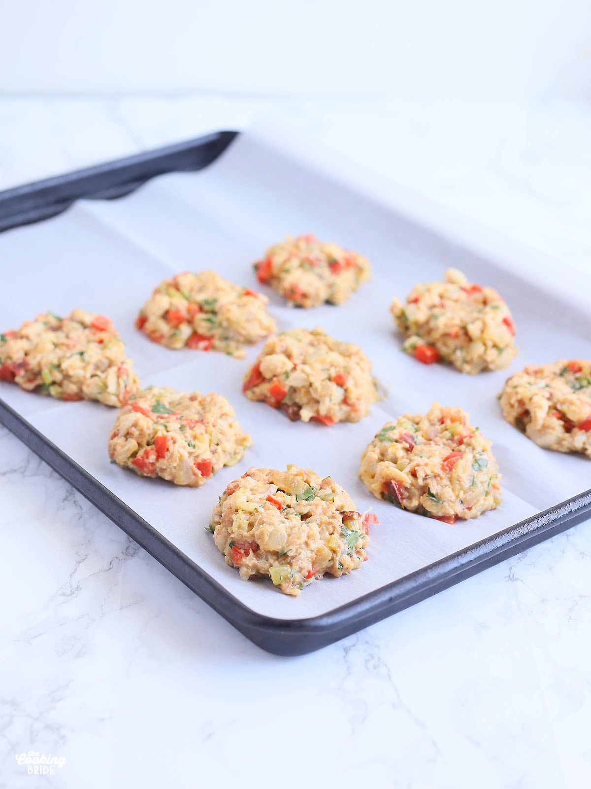 unbaked crab cakes on a baking sheet