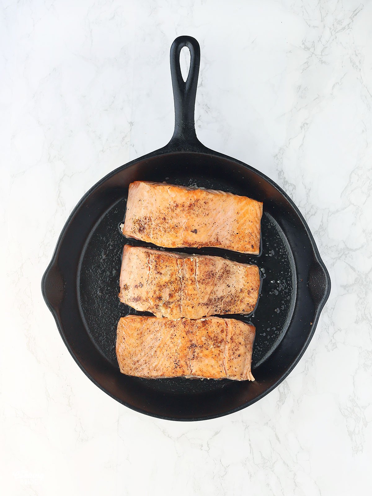 salmon filets in a cast iron skillet skin side down